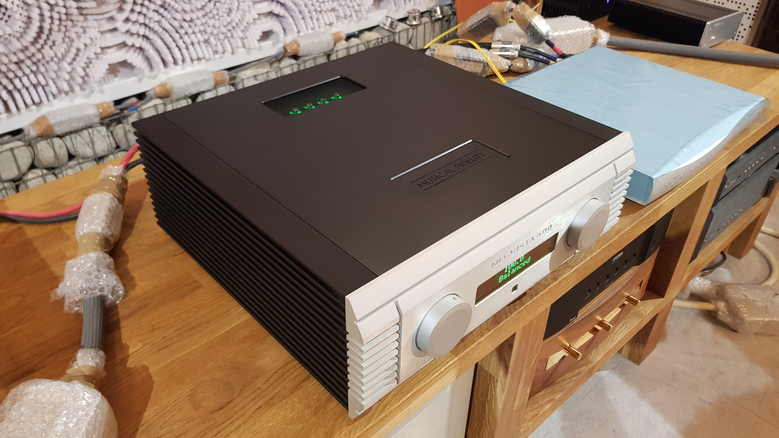 Tranzystorowy wzmacniacz zintegrowany – Musical Fidelity Nu-Vista. Konstrukcja dual mono + pre na lampach nuvistorowych. Moc: 2x220W (8Ω na kanał). Pasmo przenoszenia: 10Hz-30kHz(+-0,2dB). Wejścia: 4x rca, 1x xlr, 3 wyj.: aux, preamp out, HT. Waga ok. 40kg