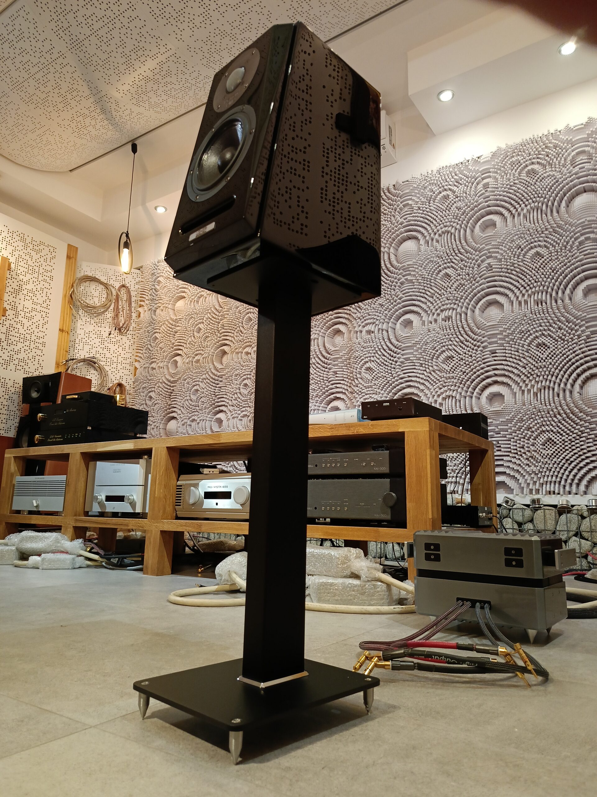 Podstawki o dużej stabilności, uniwersalne, regulowane kolce. Wysokość podstaw - 60cm, średnica nogi ca 8cm. Wymiar górnego blatu 15x20cm. Możliwość mocowania kolumn do podstaw (dedykowane otwory w blacie górnym). Wykończenie- lakier czarny mat, struktura-twarda. Możliwość zwiększenia ciężaru podstawek materiałami sypkimi.